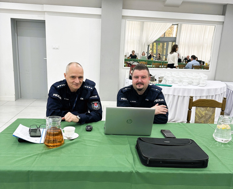 Dwóch policjantów siedzi przed laptopem.